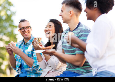 Gerne Freunde essen Sandwiches und Pizza im Freien Stockfoto