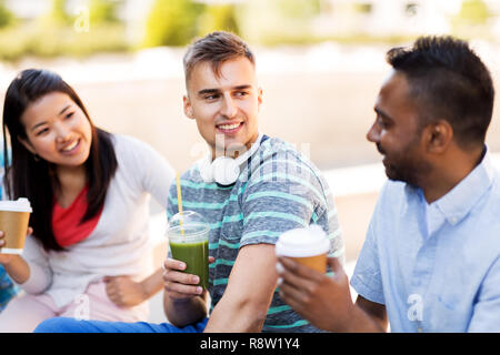 Freunde trinken Kaffee und Saft im Gespräch in Stadt Stockfoto