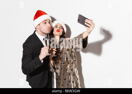 Porträt einer fröhlichen elegant gekleidete Paar stehend über weißem Hintergrund, Feiern, ein selfie Stockfoto