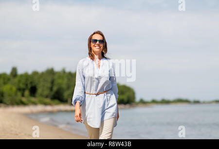 Glücklich lächelnde Frau entlang Sommer Strand Stockfoto