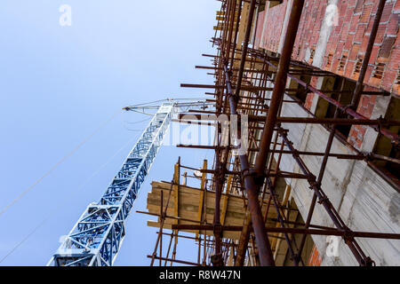 Gerüst- und Kran sind gegen unvollendete Bauwerk, Gebäude im Bau. Stockfoto