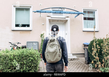 Ein Tourist geht in die Pension oder Herberge, um in ein Zimmer, dass er gebucht oder ein Student mit einem Rucksack kehrt nach seinem Studium am Institut oder auf Urlaub. Stockfoto