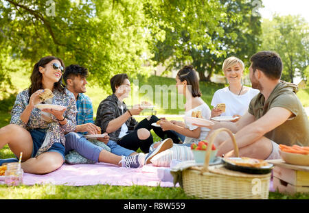 Gerne Freunde essen Sandwiches zum Sommer Picknick Stockfoto