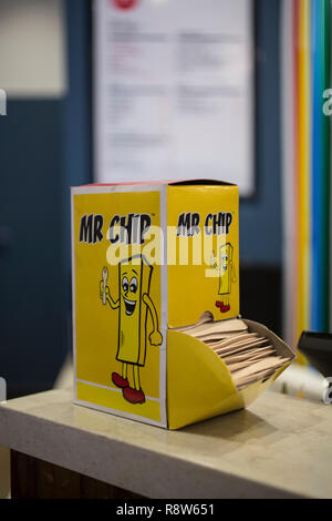 Herr Chip Holz- Fisch und chip Gabeln auf der Theke an einem London chips Shop, England, Vereinigtes Königreich Stockfoto