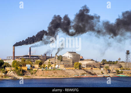 Klimawandel, globale Erwärmung: Ägyptische Zuckerfabrik auf dem Nil, Aufstoßen wogenden dicke schwarze schmutzige Rauch und Dämpfe aus der Schornsteine Stockfoto