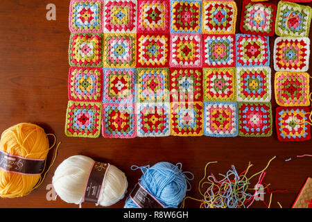 Kugeln aus Wolle für ein Hell pastellfarbenen Granny square Wolldecke Babydecke, traditionelle Handarbeit häkeln home Handwerk und Gewinde schneiden Stockfoto