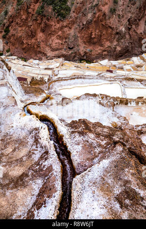 Wasserfluss, der in die Salzlachen in Maras (Salinas de Maras), Sacred Valley, Peru fließt Stockfoto