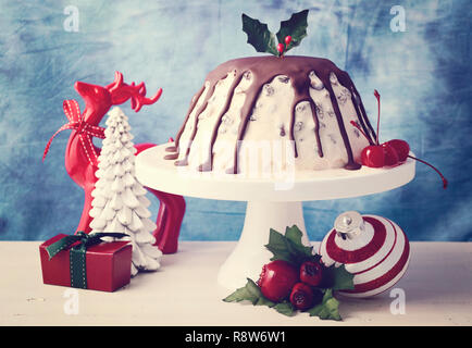 Sommer Weihnachten Eis Plum Pudding auf weißem Kuchen stand mit Rentier und Ornamenten, mit der angewandten retro Film Filter. Stockfoto