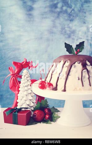 Sommer Weihnachten Eis Plum Pudding auf weißem Kuchen stand mit Rentier und Ornamenten, mit der angewandten retro Film Filter. Stockfoto