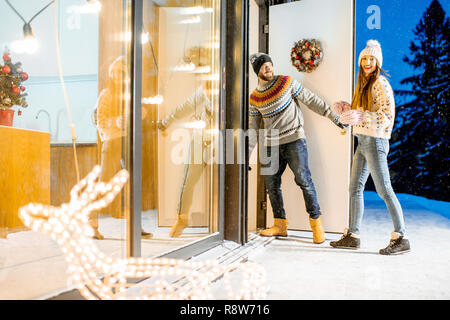 Junges Paar in den schön eingerichteten Haus durnig der Winterurlaub in den Bergen kommenden Stockfoto