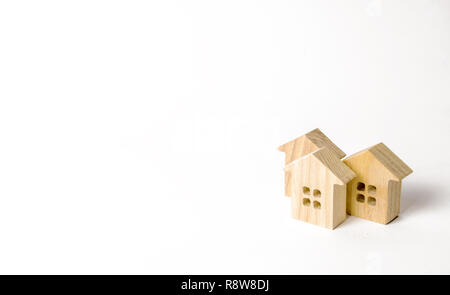 Holzfiguren von Häusern auf einem weißen Hintergrund. Minimalismus und Kopieren. Das Konzept der Immobilien, Wohnen, Kauf oder Verkauf, Miete. Settleme Stockfoto