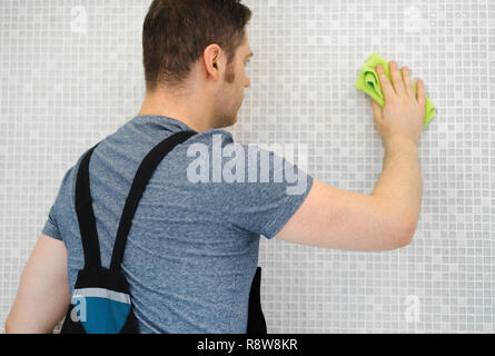Fliesenleger Reinigung Mosaik Fliesen im Badezimmer nach Reparaturen. Stockfoto