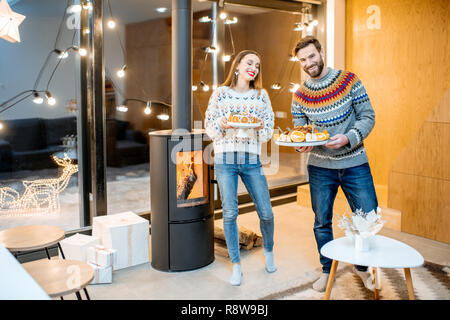 Junges Paar vorbereiten für den festlichen Abendessen in das moderne Haus während der Winterferien Stockfoto