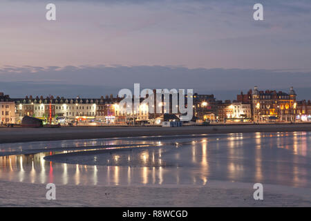 Lichter von Weymouth direkt am Meer in ruhiger Abend Wasser wider. Stockfoto