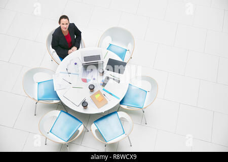 Hohen Winkel portrait zuversichtlich Geschäftsfrau am runden Tisch sitzen Stockfoto