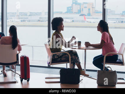 Unternehmerinnen im Gespräch und Kaffee trinken im Airport Business Lounge Stockfoto