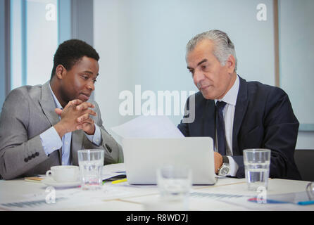 Geschäftsleute, die Papiere in Treffen diskutieren Stockfoto