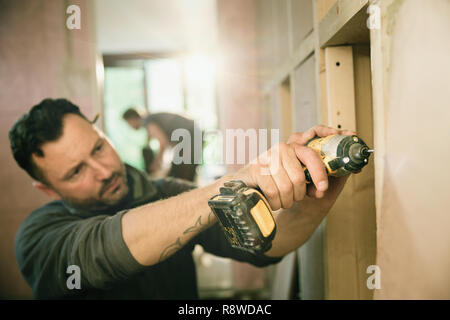 Bauarbeiter mit Bohrmaschine ausgerichtet Stockfoto