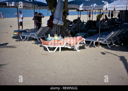 Man Sonnenbaden auf einer Liege oder lehnstuhl am Strand von Pattaya, Thailand, Südostasien Stockfoto