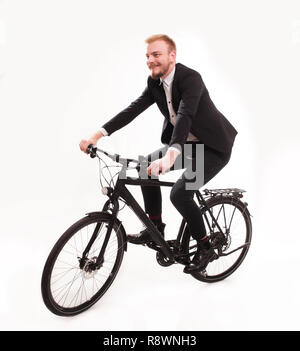 Eine junge lächelnde Mann, 20-29 Jahre, in Anzug gekleidet, formale tragen. sitzt auf einem Fahrrad, Radfahren im Studio auf isolierten weißen Hintergrund. Stockfoto