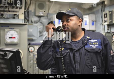 Atlantischer Ozean (10. März 2017) - Der Chief Machinist Mate Justin die Ford Motor Company verwendet Engineering stand Communications System Aufträge an Personen zu geben, die sich im Maschinenraum an Bord der Amphibisches Schiff USS Iwo Jima (LHD7). Iwo Jima ist im Gange, die in einer Reihe von Qualifikationen und Zertifizierungen als Teil des grundlegenden Phase der Ausbildung in Vorbereitung auf die künftige Operationen und Bereitstellungen. Stockfoto