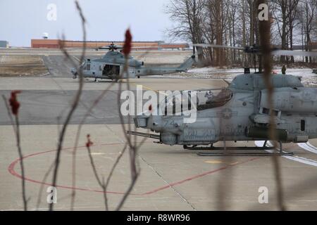 Ein UH-1Y Venom und eine AH-1W Super Cobra für den Start bei kaltem Wetter an Bord Fort Drum, NEW YORK, 8. März 2017 vorzubereiten. Das Training, das am 8. März begann, die Marines mit Marine Light Attack Helicopter Squadron 269, Marine Flugzeuge Gruppe 29, 2. Marine Flugzeugflügel, zusammen mit verschiedenen anderen Einheiten über das Verteidigungsministerium. Die Marines erfahren Sie, wie Sie mit den Herausforderungen, die die Arbeit mit im kalten, und manchmal verschneiten und eisigen Umgebungen kommen. Stockfoto