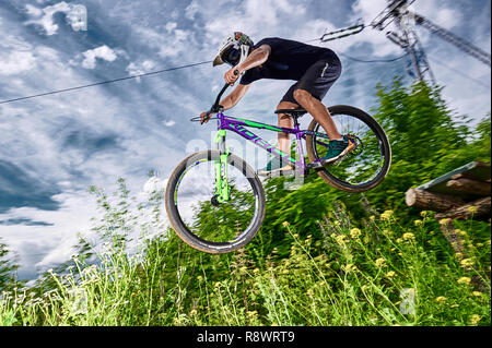 Moskau, Russland - Juli 6, 2017: Springen und auf dem Mountainbike fliegen. Reiter in Aktion bei Mountain bike Sport. Biker einen Stunt und Schritt nach unten springen. Co Stockfoto