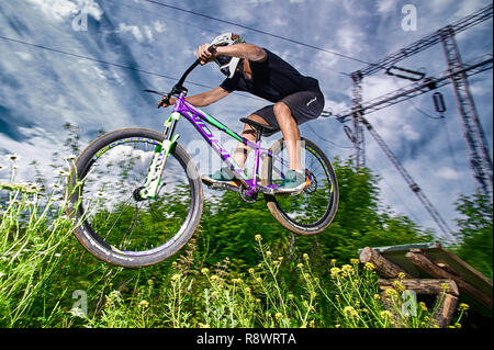 Moskau, Russland - Juli 8, 2017: Springen und auf dem Mountainbike fliegen. Reiter in Aktion bei Mountain bike Sport. Biker einen Stunt und Schritt nach unten springen. Co Stockfoto