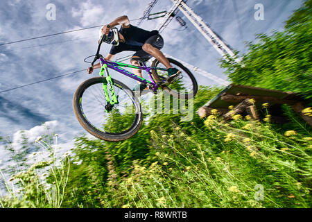 Moskau, Russland - Juli 6, 2017: Springen und auf dem Mountainbike fliegen. Reiter in Aktion bei Mountain bike Sport. Biker einen Stunt und Schritt nach unten springen. Co Stockfoto