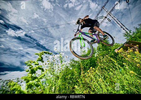 Moskau, Russland - Juli 7, 2017: Auf dem Mountainbike springen. Reiter in Aktion bei Mountain bike Sport. Biker einen Stunt und Schritt nach unten springen. Cool athle Stockfoto