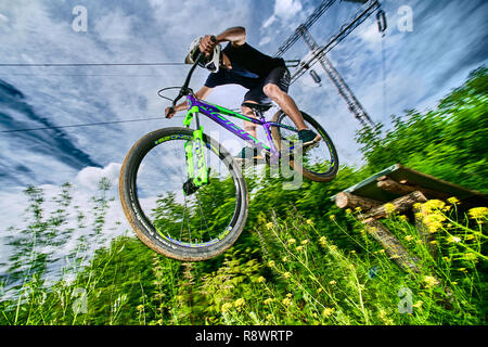 Moskau, Russland - Juli 7, 2017: Auf dem Mountainbike springen. Reiter in Aktion bei Mountain bike Sport. Biker einen Stunt und Schritt nach unten springen. Cool athle Stockfoto