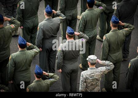 Mitglieder der 374 Gruppe Betrieb begrüssen bei einem Rückzug Zeremonie März 17, 2017, Yokota Air Base, Japan. Die Exerzitien Zeremonie dient als eine Art und Weise Bezug auf die Fahne zu bezahlen und das Ende des offiziellen Pflicht Tag mit dem Abspielen der US-Nationalhymne beim Absenken und Falten die Flagge. Stockfoto