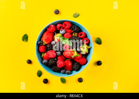 Blick von oben auf die Beere Schüssel auf gelben Hintergrund. Saubere Konzept Essen Stockfoto