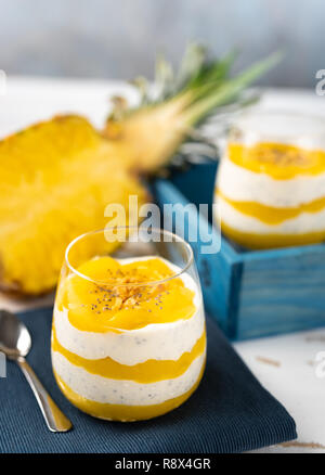 Vertikaler smoothie Mango und Ananas mit Joghurt in zwei Gläser Stockfoto