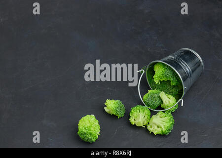 Placer grün Brokkoli Segmente von einer kleinen Schaufel. Gesunde Ernährung auf dunklem Hintergrund. Kopieren Sie Raum, Ansicht von oben. Vegetarisches Essen. Stockfoto