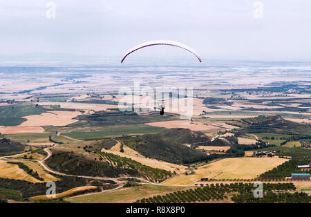 Gleitschirm silhouette Fliegen über Tal in Loarre, Huesca, Spanien. Stockfoto