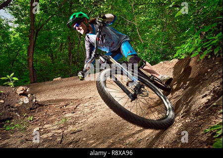 Moskau, Russland - Juli 6, 2017: Biker reiten mit aggressiven dreht. Mountainbike Radfahrer reiten Single Track. Reiter in Aktion bei Mountain bike Sport. Stockfoto