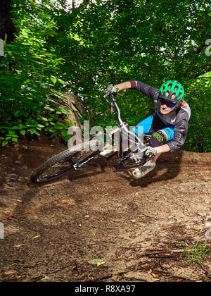 Moskau, Russland - Juli 8, 2017: Biker reiten mit aggressiven dreht. Mountainbike Radfahrer reiten Single Track. Reiter in Aktion bei Mountain bike Sport. Stockfoto