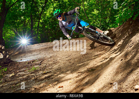 Moskau, Russland - Juli 6, 2017: Biker reiten mit aggressiven dreht. Mountainbike Radfahrer reiten Single Track. Reiter in Aktion bei Mountain bike Sport. Stockfoto