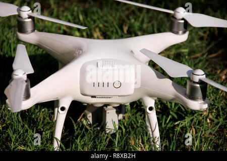Weiß quadcopter Drone mit 4K-Digitalkamera auf Gras ist bereit zum Abheben in die Luft zu fliegen, um zu fotografieren, aufnehmen Aufnahmen von oben. Drone. Stockfoto