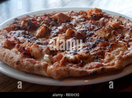 Ein gegrilltes Huhn Pizza mit getrockneten Tomaten, Mozzarella, Jamaican Jerk Seasoning und Marinara ist an soulshine Pizza in Oxford, Mississippi serviert. Stockfoto