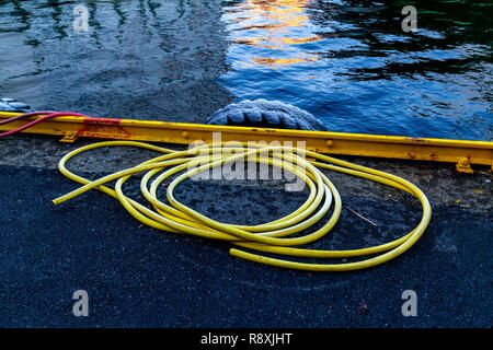 Gelbe Kunststoffschlauch Verlegung auf dem Asphalt, und gelben Rampe auf einem Kai im Hafen von Bergen, Norwegen Stockfoto