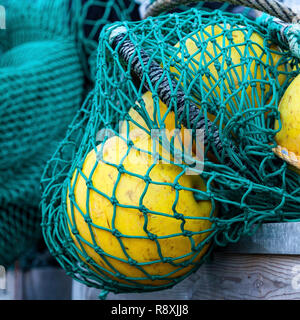 Bündel von grünen Fischernetze und gelben Bojen. Stockfoto