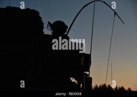 Eine britische Soldaten zu US 4 Squadron angebracht, 2.Kavallerie Regiments, mountet ein Schakal kämpfen Fahrzeug oder Mobilität Weapon-Mounted Installation Kit - MWMIK, während am frühen Morgen einen Konvoi am Joint Multinational Readiness Center in Hohenfels, Deutschland, 12. März 2017. Usa und Großbritannien Truppen nahmen an einer Validierung Übung leader Kenntnisse zu testen, Kommunikation Interoperabilität und die Koordinierung mit benachbarten Anlagen. Stockfoto