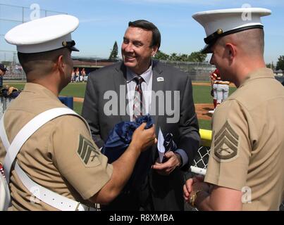 Marine Corps Recruiters SSgt. Phillip Seite und Sgt. Victor Romauldo Rekrutierung Unterstation Lakewood ein Geschenk der Wertschätzung für die ehrenwerte Dan Koops, Bürgermeister von glockenblume Stadt präsentieren, bevor ein Baseball Varsity Spiel in St. Johannes Bosco High School in Bellflower, Kalifornien, USA, 14. März 2017. Stockfoto