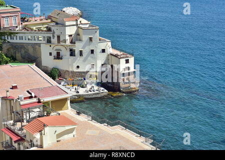 Mediterrane Terrasse Häuser bauen auf steilen felsigen Klippen entlang der zerklüfteten Küste direkt über dem blauen Meer Oberfläche. Stockfoto