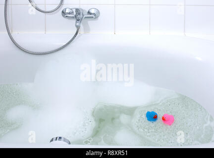 Rosa und Blaue Ente in eine Badewanne, Seife umgeben Stockfoto