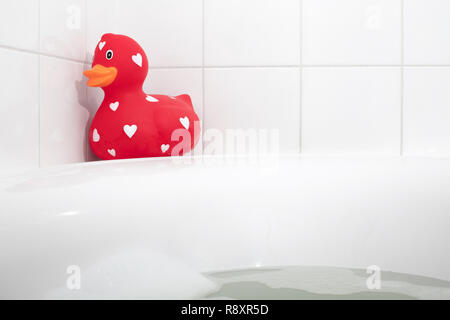 Großes rotes Quietscheentchen in der Badewanne, selektiver Fokus Stockfoto