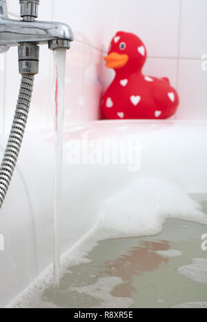 Großes rotes Quietscheentchen in der Badewanne, selektiver Fokus Stockfoto