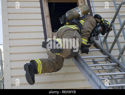 Ein Feuerwehrmann aus dem 92. Tiefbau Squadron Feuerwehr Praktiken eine Flucht Technik bei Fairchild Air Force Base, Washington, März 17, 2017. Us Air Force Feuerwehrmänner spezialisierten Ausbildungseinrichtungen nutzen zu simulieren, die Sie in einem echten Feuer ausgesetzt sein können. Stockfoto